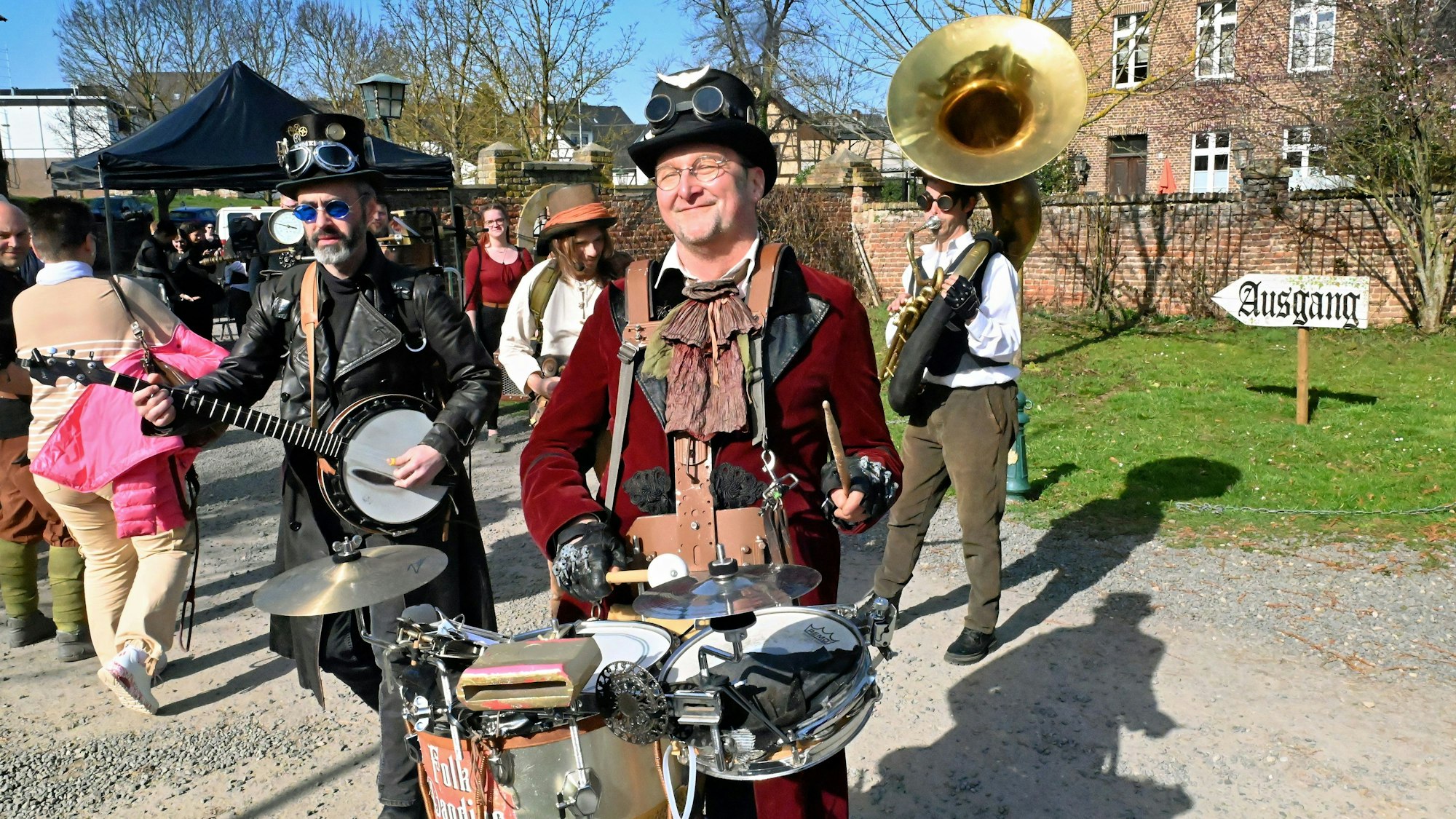 Auch das Quartett hat sich im Stil des Szenemarktes verkleidet. Die vier Musiker haben Kostüme, die dem Steampunk zuzurechnen sind, angezogen und spielen im Freien.