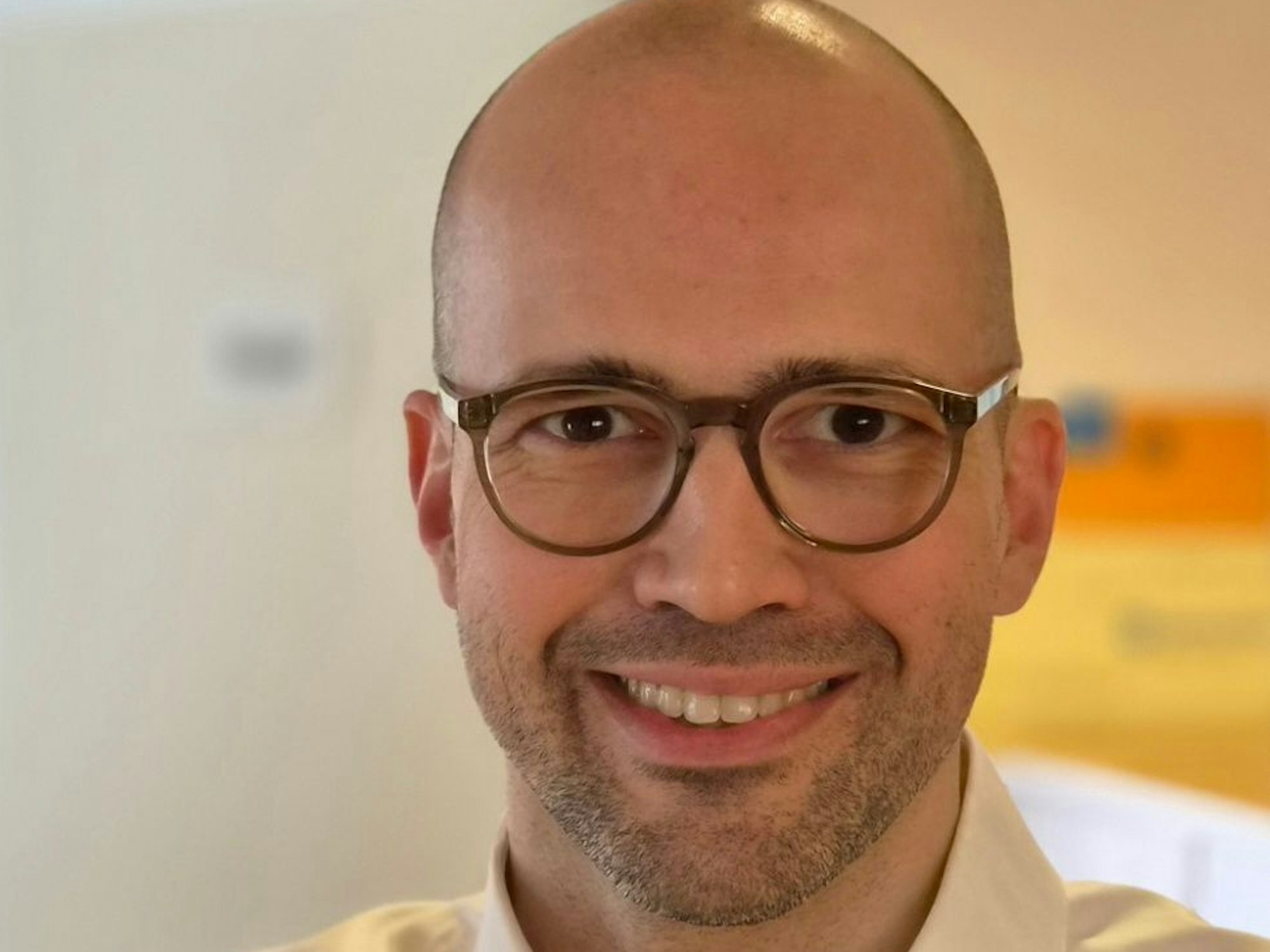 Allergologe Dr. Marc Schönherr ist im Porträt zu sehen, er lächelt in die Kamera.