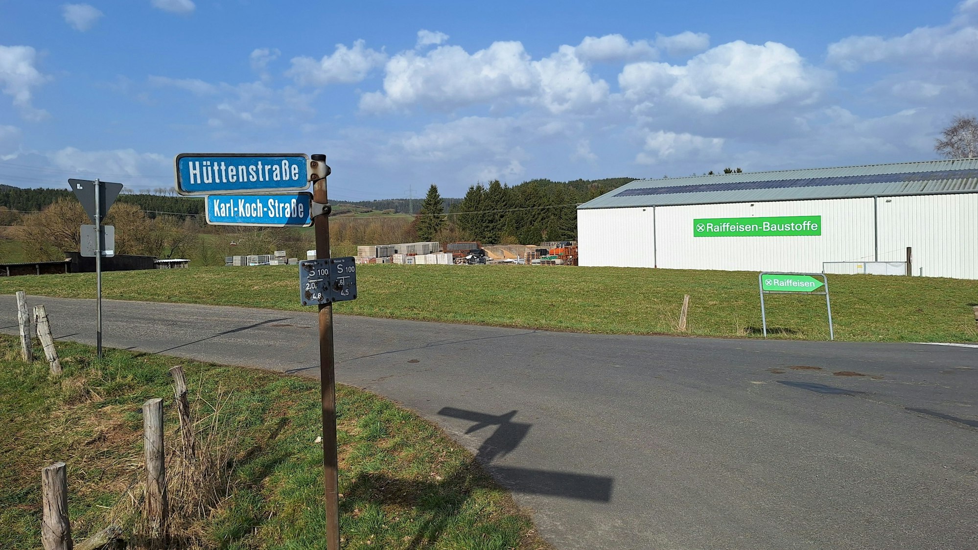 An der Kreuzung Hüttenstraße/Karl-Koch-Straße in Dahle-Baasem ist im Hintergrund eine Halle zu sehen.