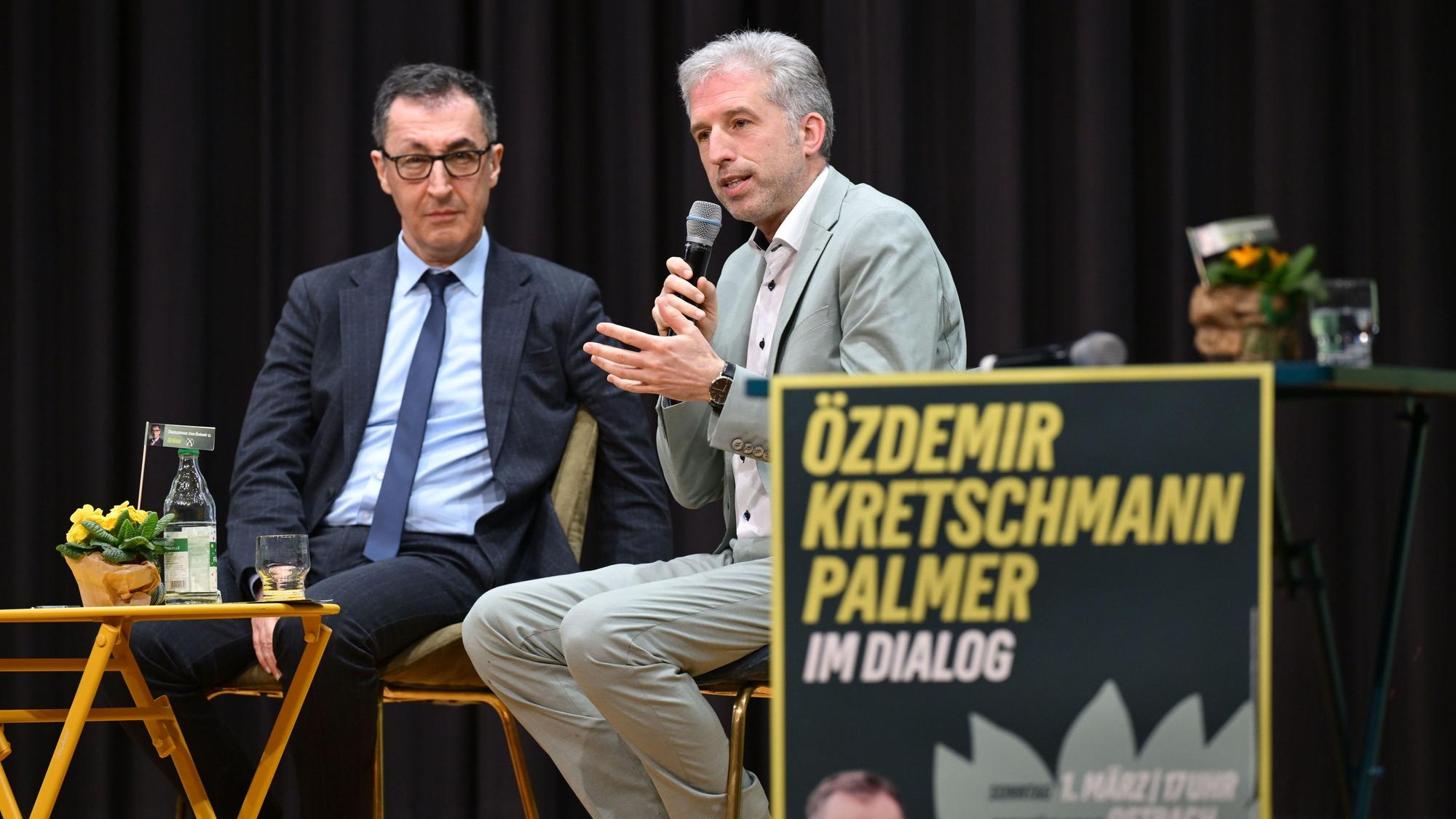 Ostrach: Cem Özdemir (Bündnis 90/Die Grünen, l.) und Tübingens Oberbürgermeister Boris Palmer (parteilos) sprechen auf einer Bühne bei einer Wahlkampfveranstaltung der Grünen in der Ostracher Buchbühlhalle.