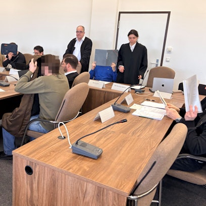 Die fünf Angeklagten mit ihren Verteidigern beim Prozessauftakt in Saal 112 des Kölner Landgerichts