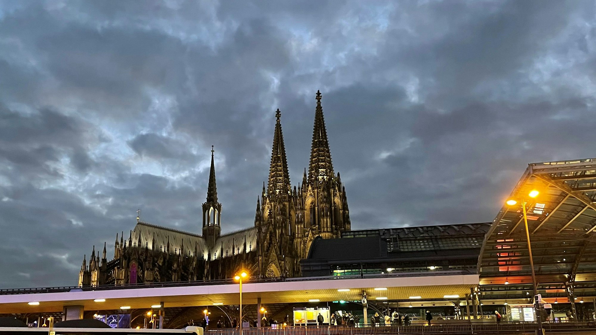 Der beleuchtete Kölner Dom hinter dem Bahnhof. (Archivbild)