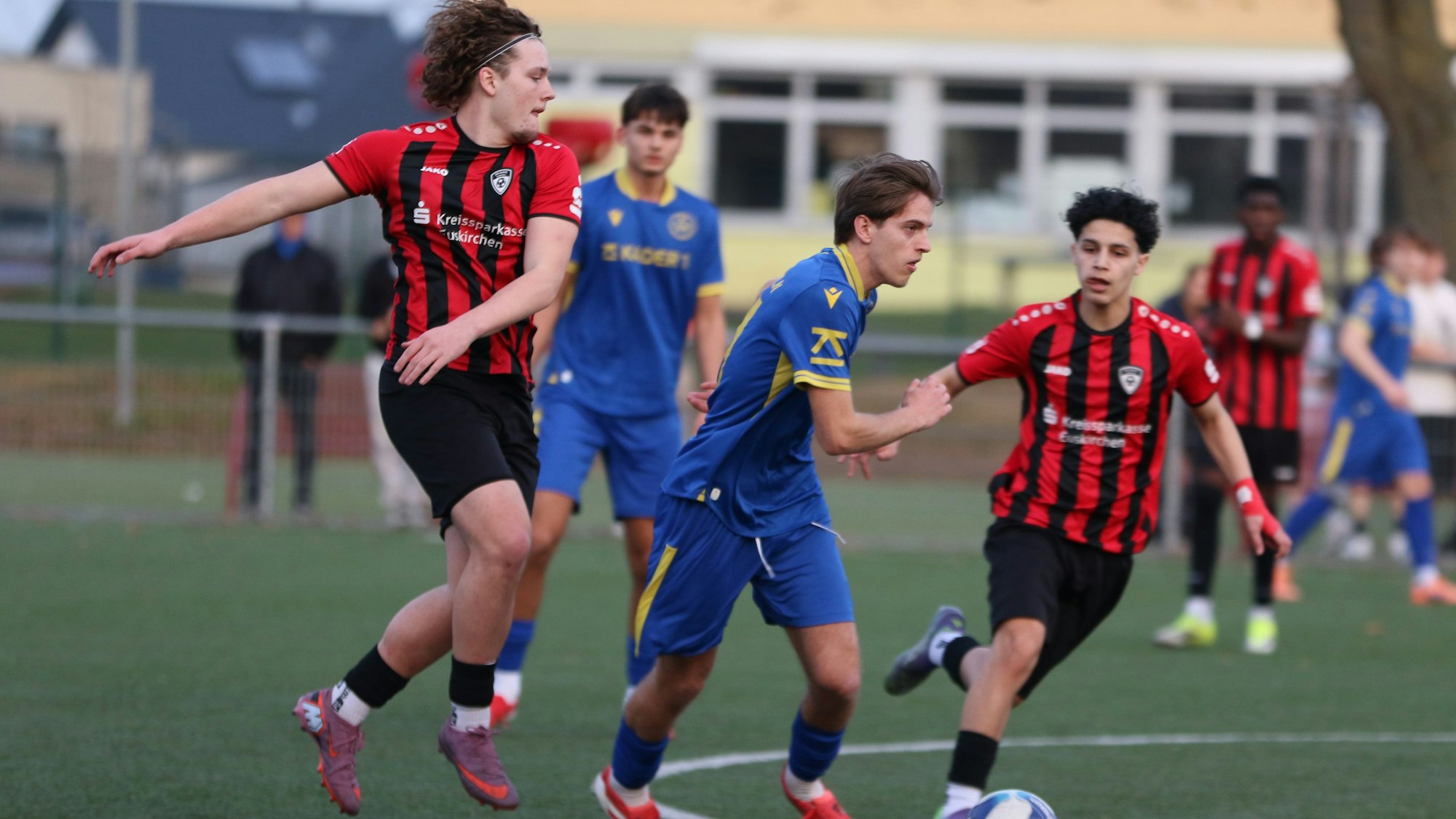 Die Erft-Spieler Luke Gossing (l.) und Adam Bouyardan (4.v.l.) grifen einen Gegenspieler des SC West an.