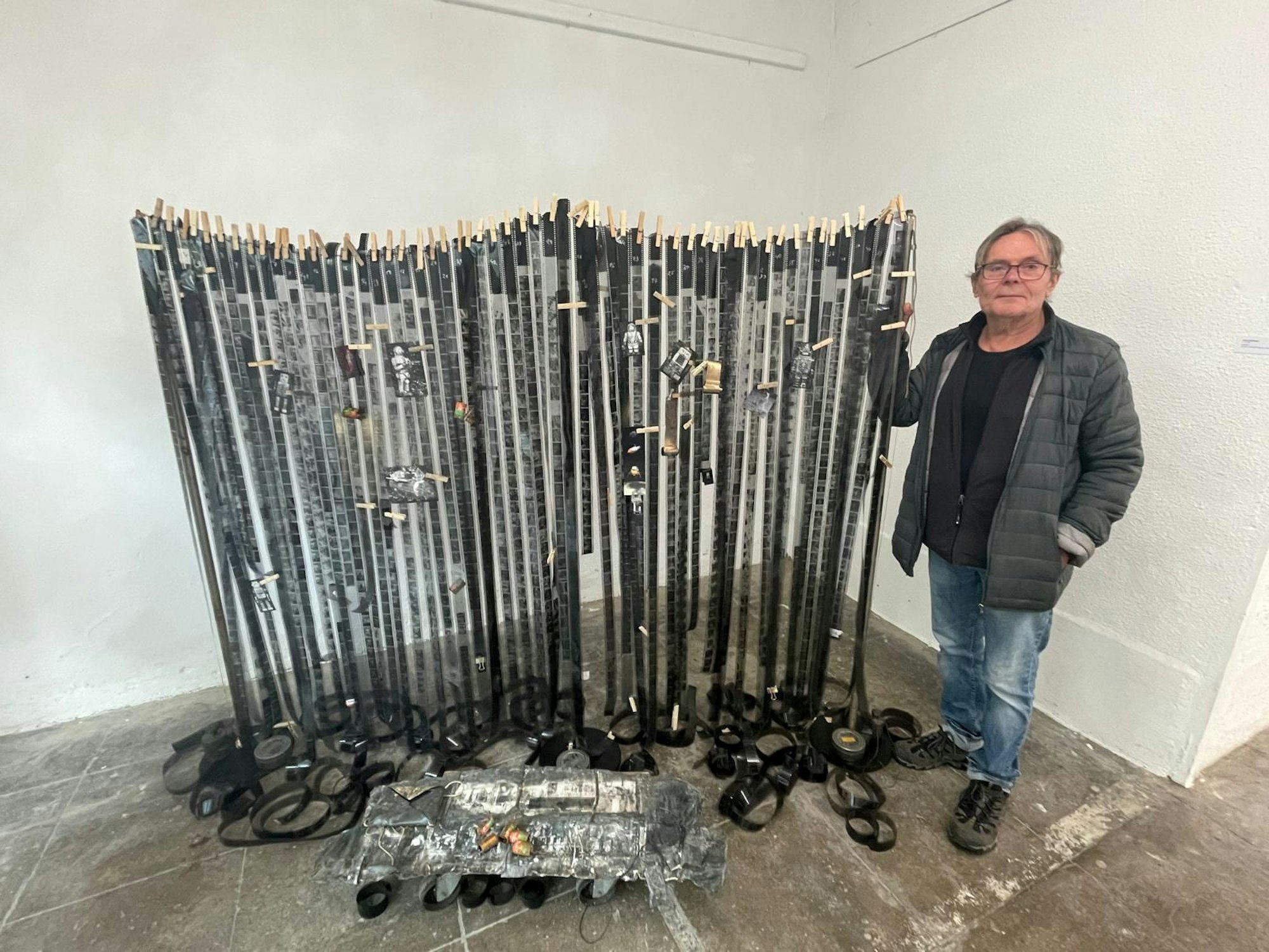 Jürgen Dehniger steht neben seiner Installation aus Filmrollen