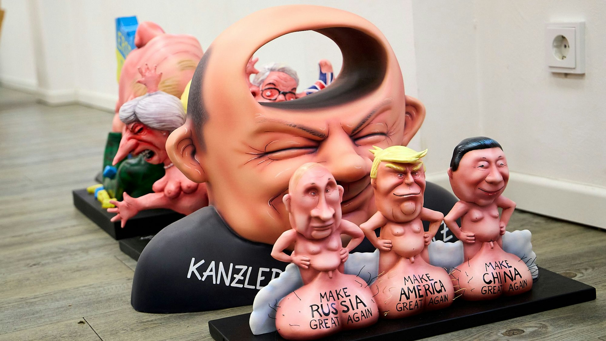 Im Vordergrund sind die Staatsführer der USA, Russlands und Chinas zu sehen, dahinter Olav Scholz, durch dessen Kopf ein Tunnel führt.