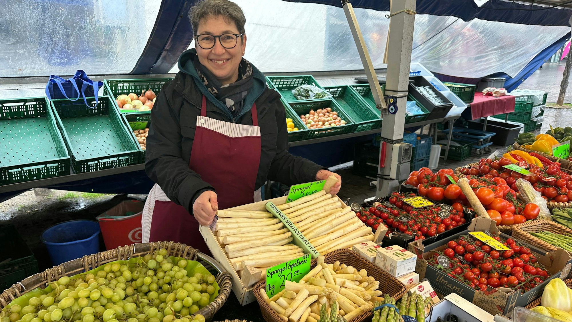 Fadime Sezer lächelt in die Kamera und steht vor einer Kiste Spargel.