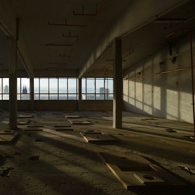 Eine leere Fabriketage. Durch ein Fenster sind die Domspitzen zu sehen.