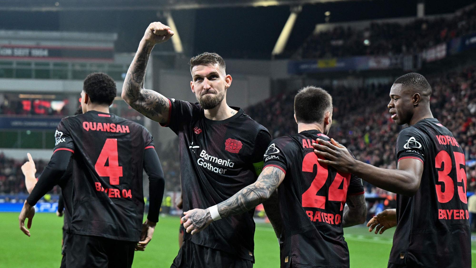 TOPSHOT - Bayer Leverkusen's German midfielder #08 Robert Andrich (2L) and teammates celebrate scoring their team's first goal during the UEFA Champions League, Last 16, first-leg football match Bayer 04 Leverkusen vs Arsenal in Leverkusen, western Germany, on March 11, 2026. (Photo by UWE KRAFT / AFP)