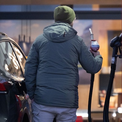 Ein Mann hält an einer Tankstelle eine Zapfpistole. (Symbolfoto)