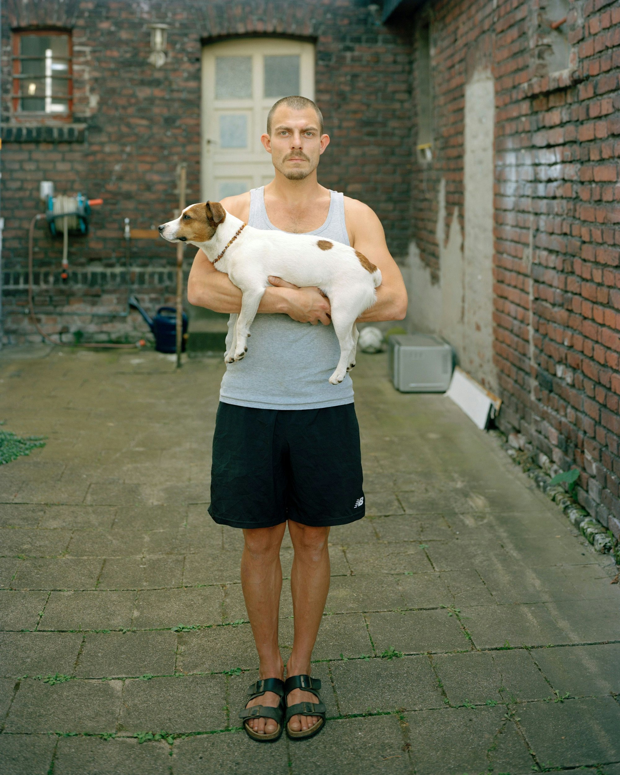 Ein Mann hält seinen Hund im Arm.