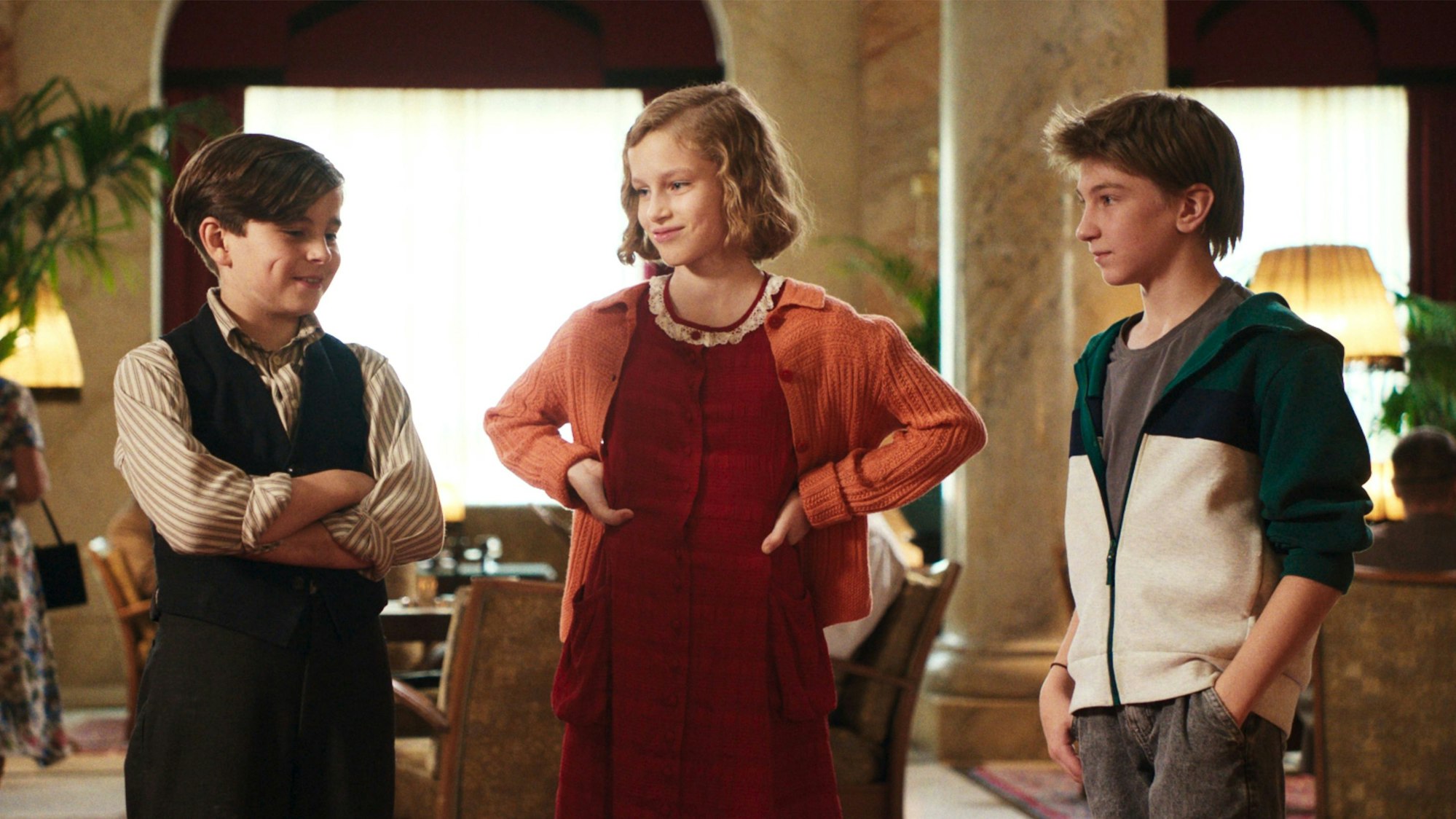 Drei Kinder stehen nebeneinander und schauen sich an.