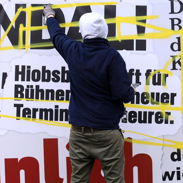 Ein Künstler gestaltet den Frustzaun an der Oper um.