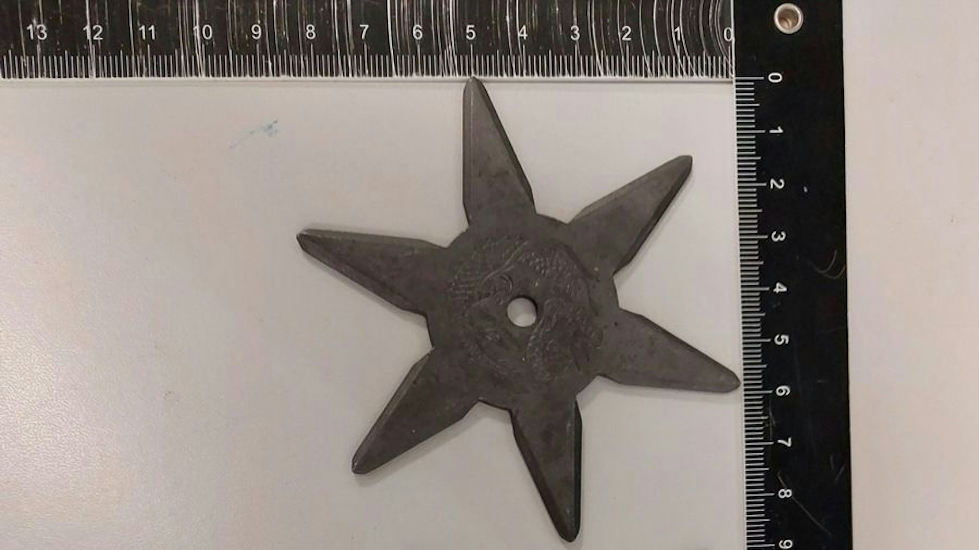 Drei Wurfsterne liegen auf einem Tisch.