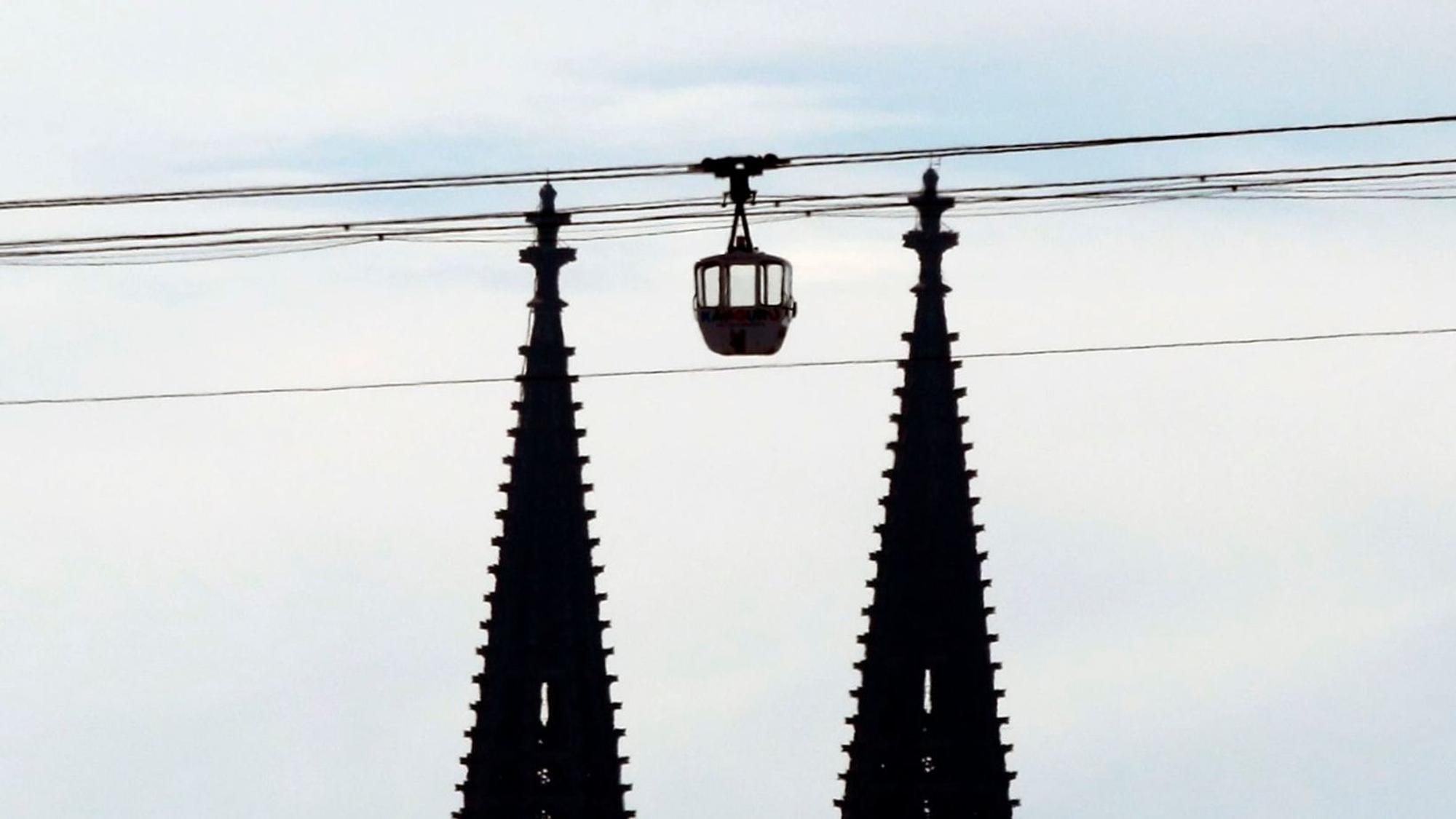 Die Seilbahn fährt wieder. Eine Gondel schwebt zwischen den beiden Türmen des Kölner Doms. (Archivbild)