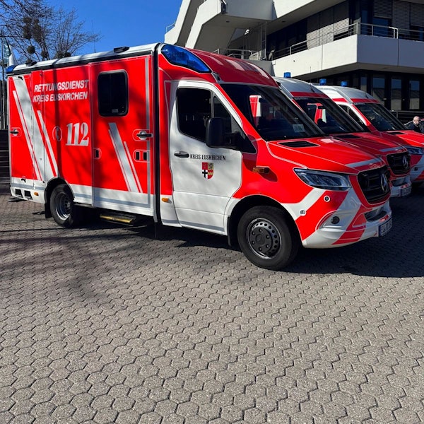 Ein Rettungswagen und zwei Krankentransportwagen stehen vor dem Kreishaus in Euskirchen.