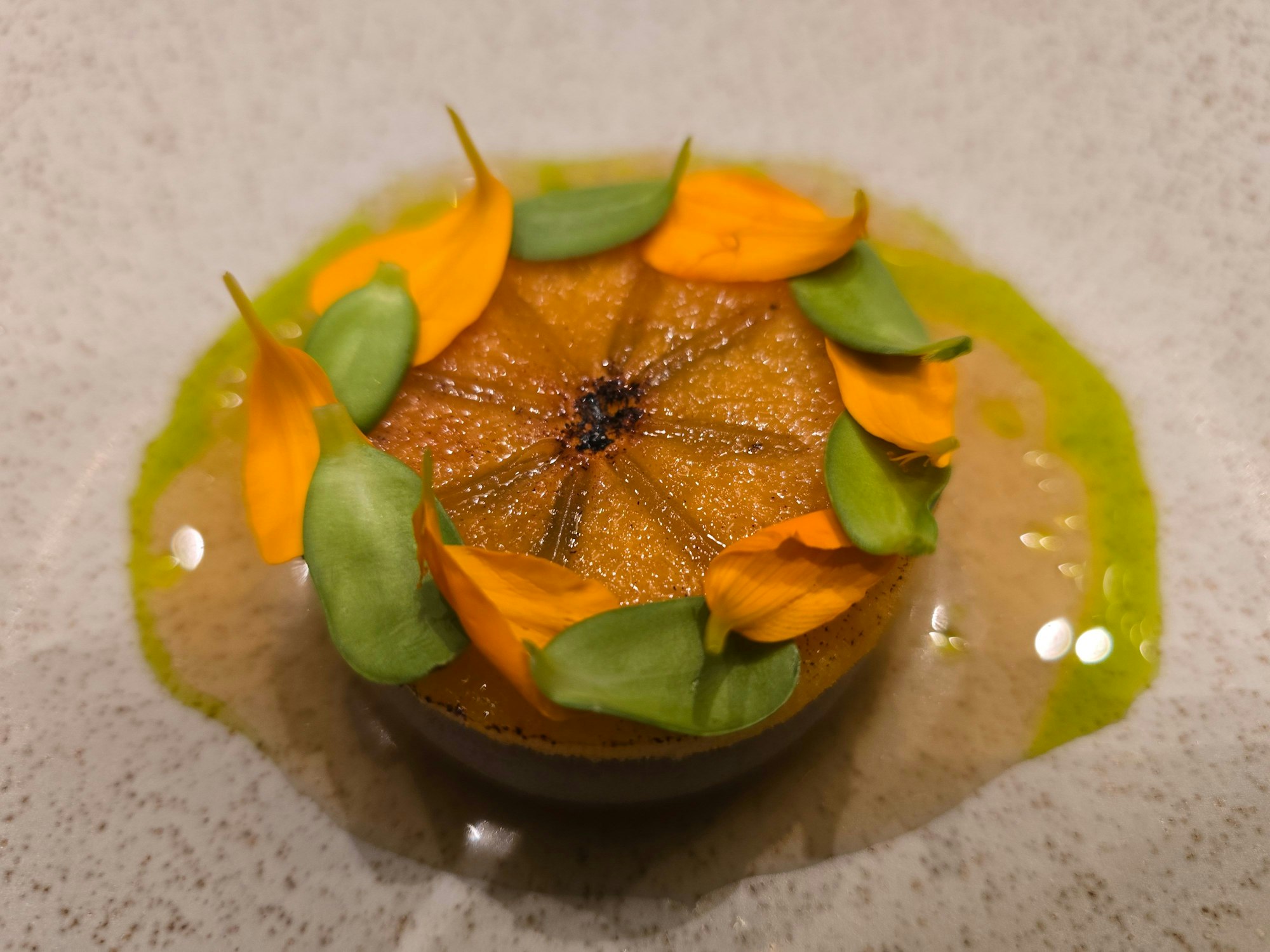 Ein aufwändig angerichteter Teller mit Blüten und Blättern ist zu sehen.