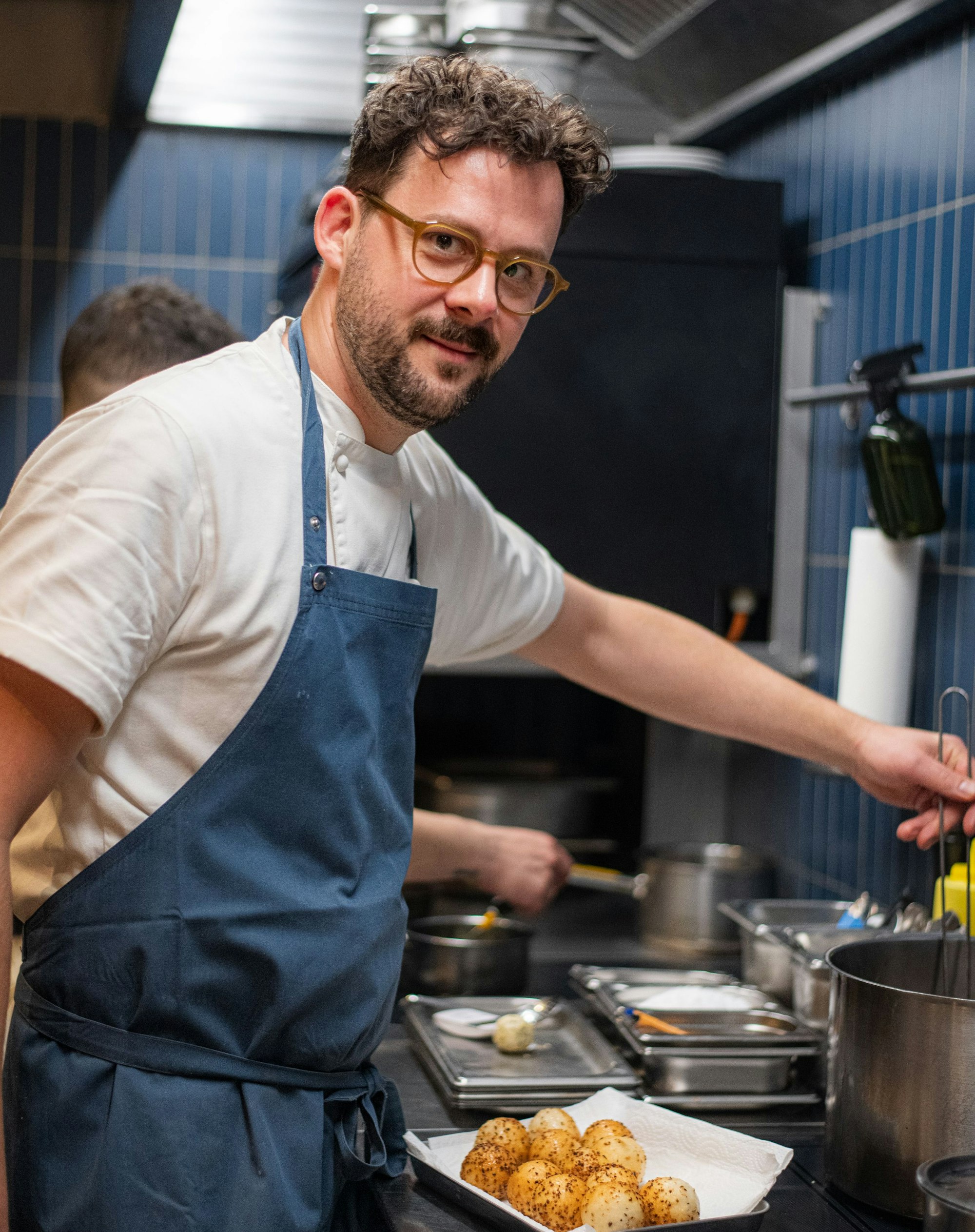 Herr Sablotny steht in der Küche vor einem Teller und schaut in die Kamera.