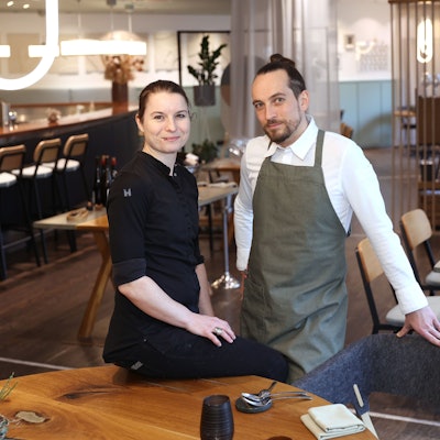 Sonja Baumann und Erik Scheffler sind im Restaurant zu sehen. Sie lächeln in die Kamera.