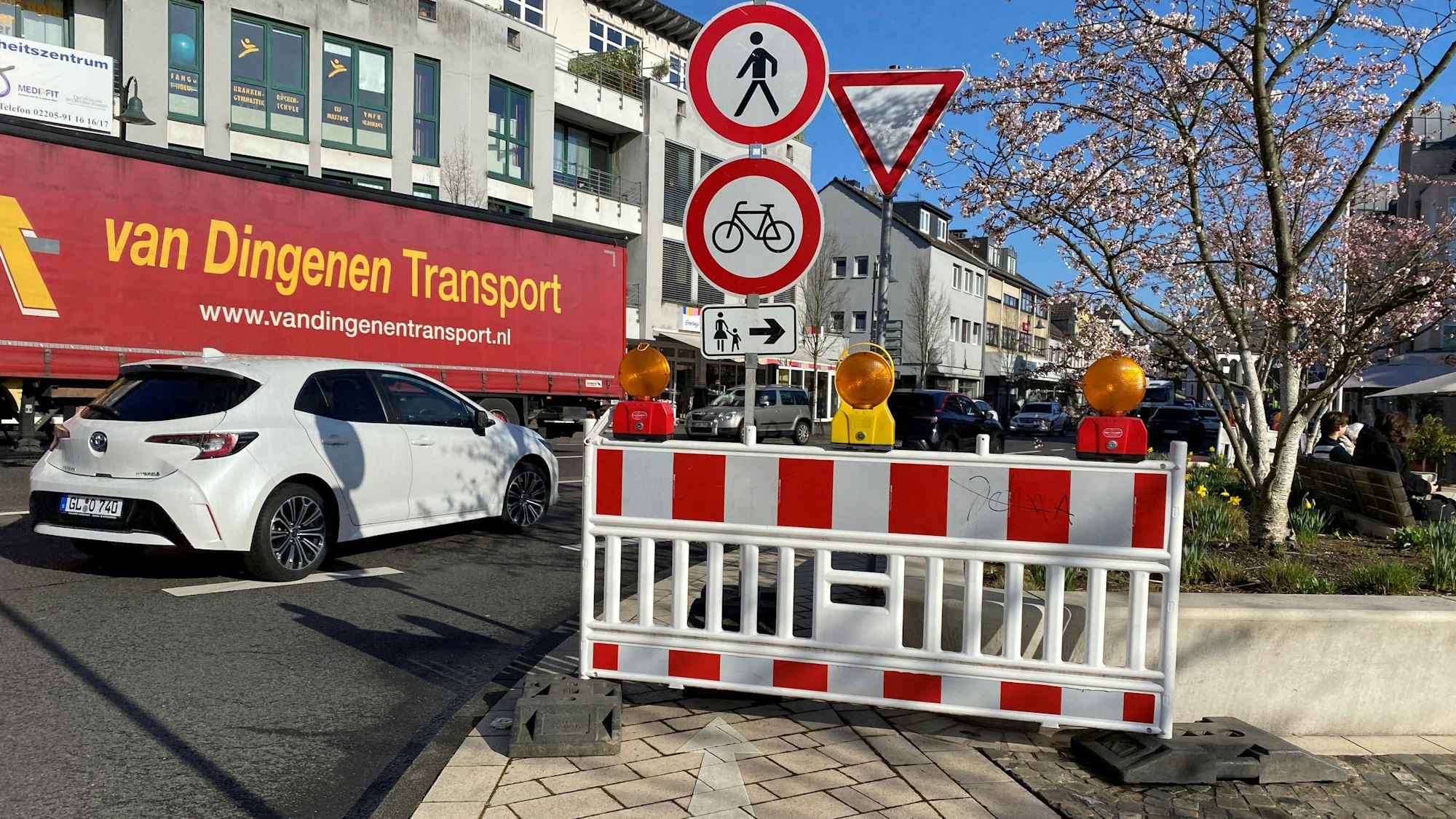 Eine Bake mit einem Durchgangsverbotsschild für Fußgänger und Radfahrende, im Hintergrund ein Lkw und ein Auto