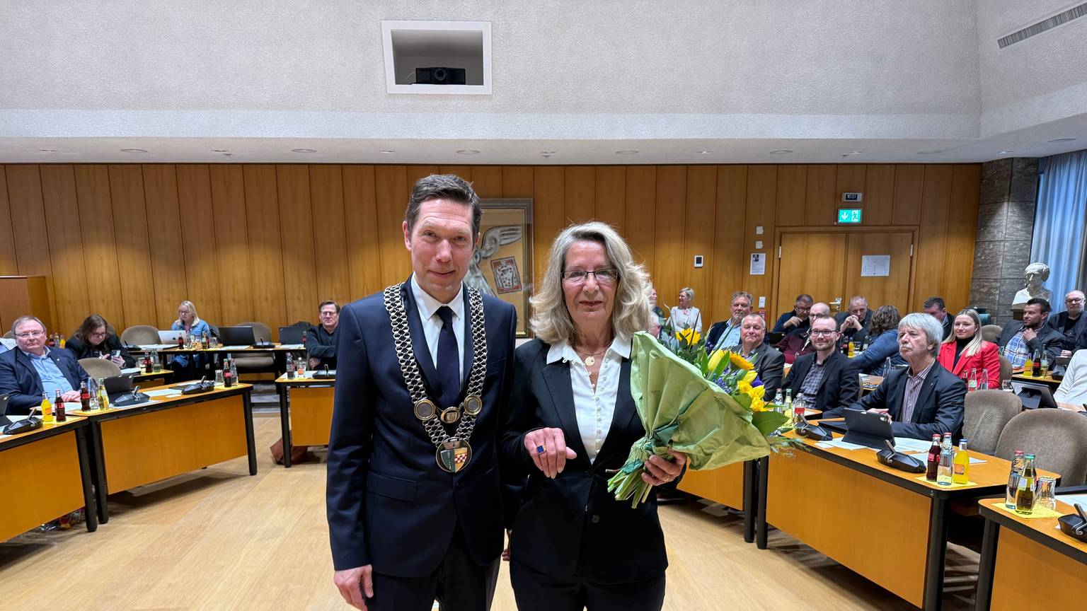 Bürgermeister Raoul Halding-Hoppenheit und Helga Auerswald mit einem Blumenstrauß und dem Ehrenring