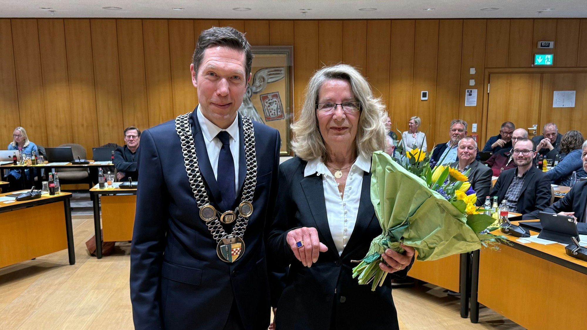 Bürgermeister Raoul Halding-Hoppenheit und Helga Auerswald mit einem Blumenstrauß und dem Ehrenring