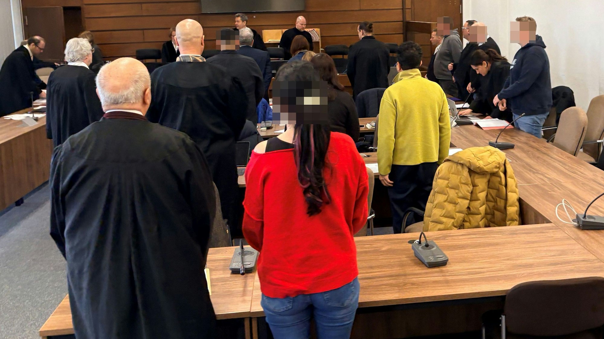 Die sieben Angeklagten mit ihren Verteidigern beim Prozessauftakt im Kölner Landgericht