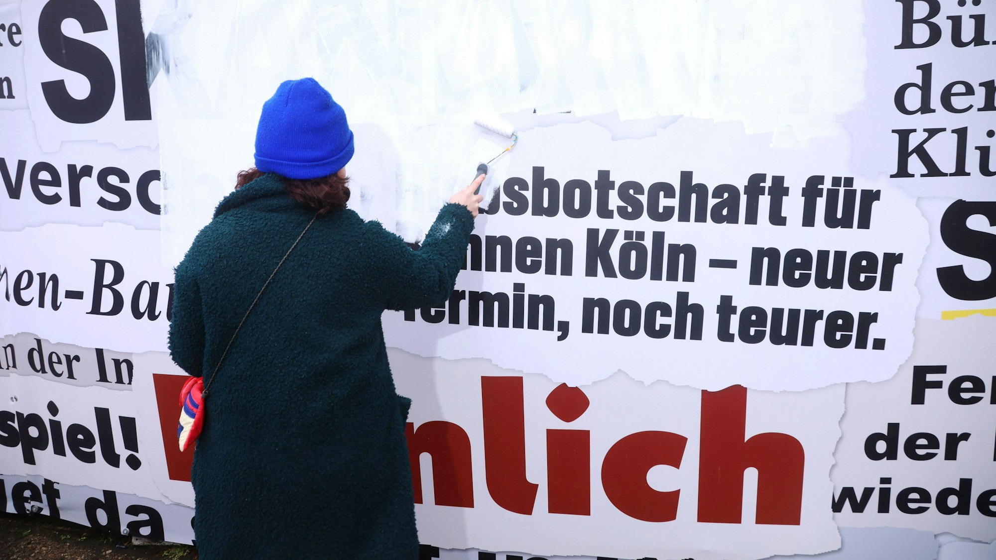 11.03.2026, Köln: Die Kölner Bühnen haben rund um die Opernbaustelle einen als Frustzaun bezeichneten Bauzaun geschaffen, der mit zahlreichen negativen Schlagzeilen rund um die Sanierung beklebt ist. In einer Künstlerischen Aktion soll der Zaun jetzt umgestaltet werden. Foto: Arton Krasniqi