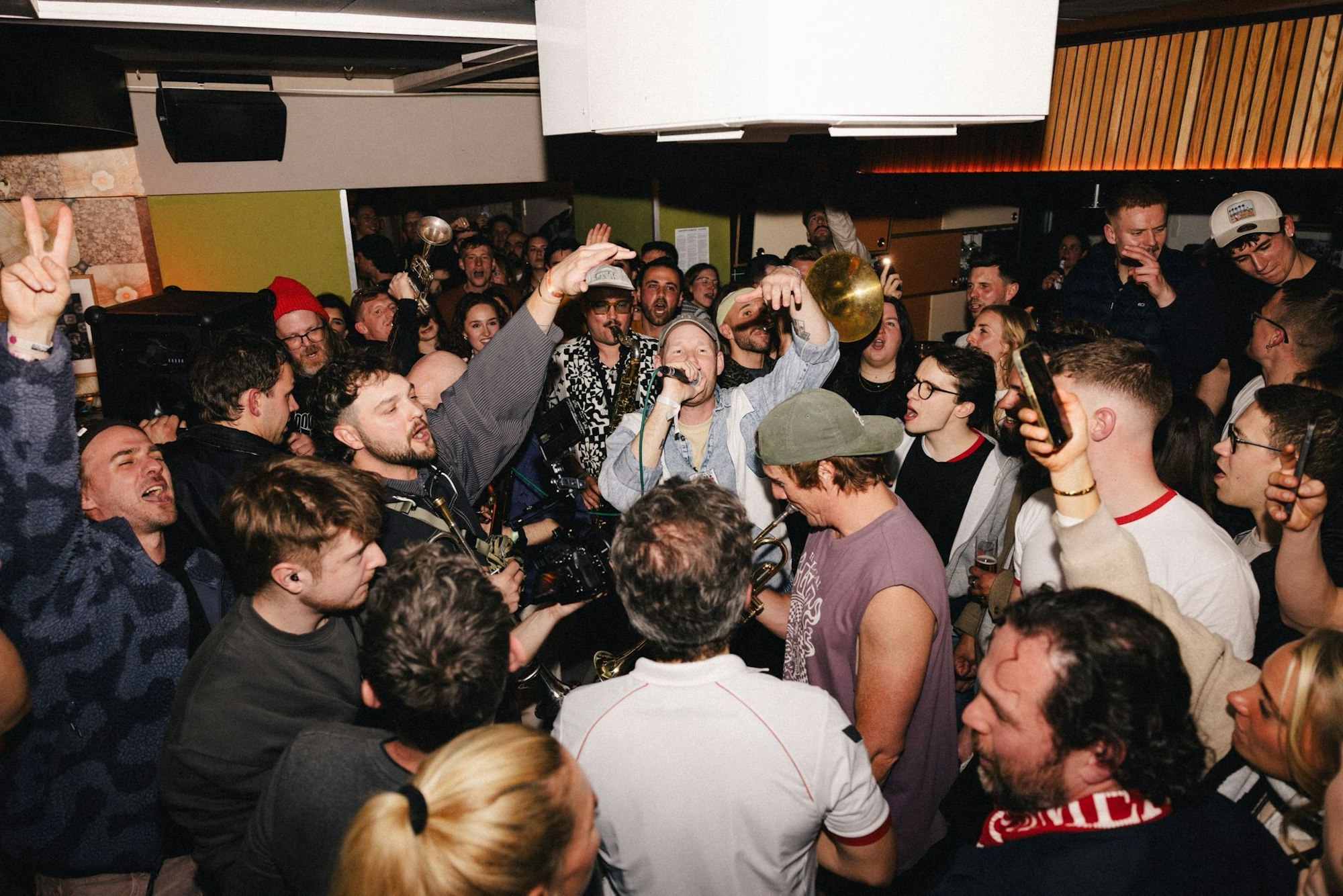 Querbeat feiert die Verkündung, dass die Band im Juni 2027 ein Konzert im Rhein-Energie-Stadion spielt mit spontanen Auftritten in Kölner Kneipen.