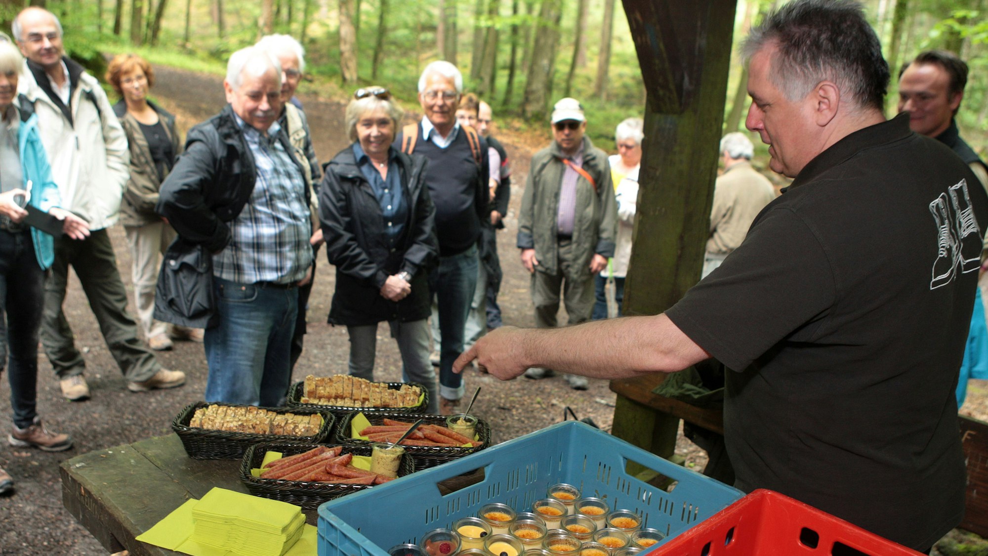 Gastronom Markus Wißkirchen bietet an einer Schutzhütte im Wald Wanderen Leckeres aus seiner Küche an.