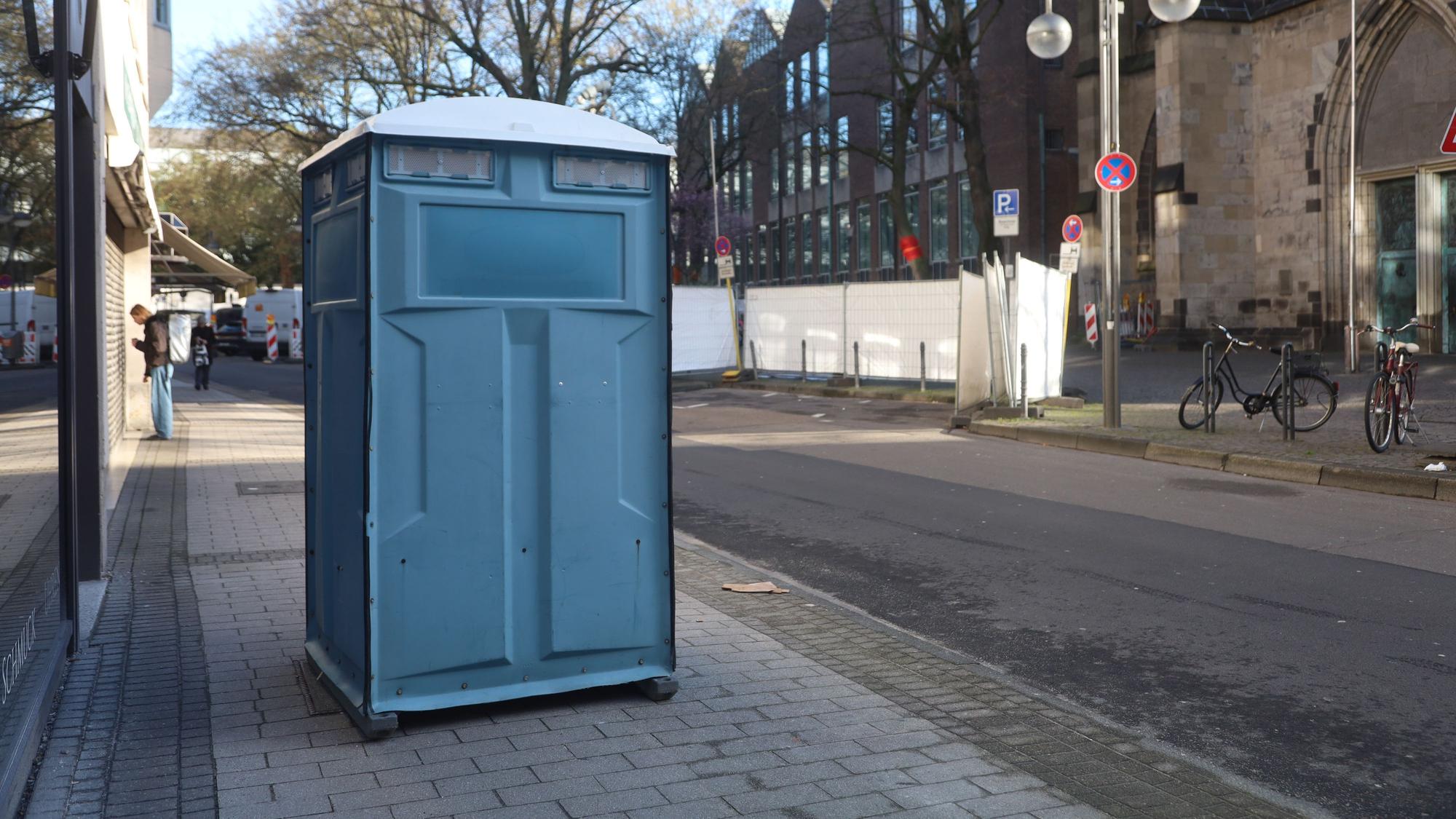 Ein Dixi-Klo mitten auf dem Gehweg.