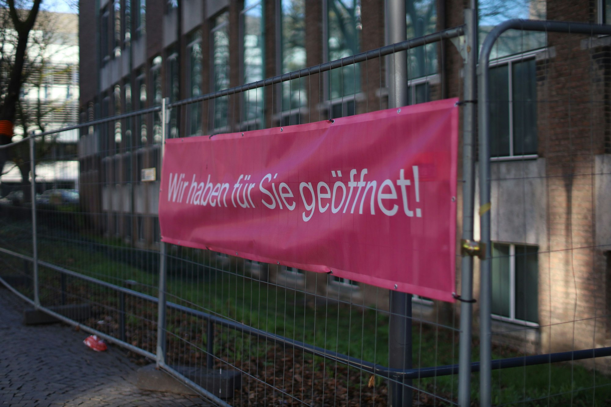 Auf einem Transparent steht: „Wir haben für Sie geöffnet.“