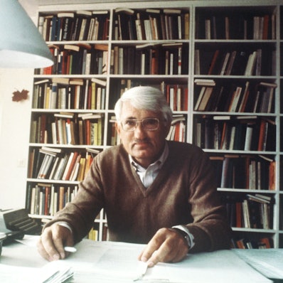 Jürgen Habermas, sitzt vor einer Bücherwand an seinem Schreibtisch.
