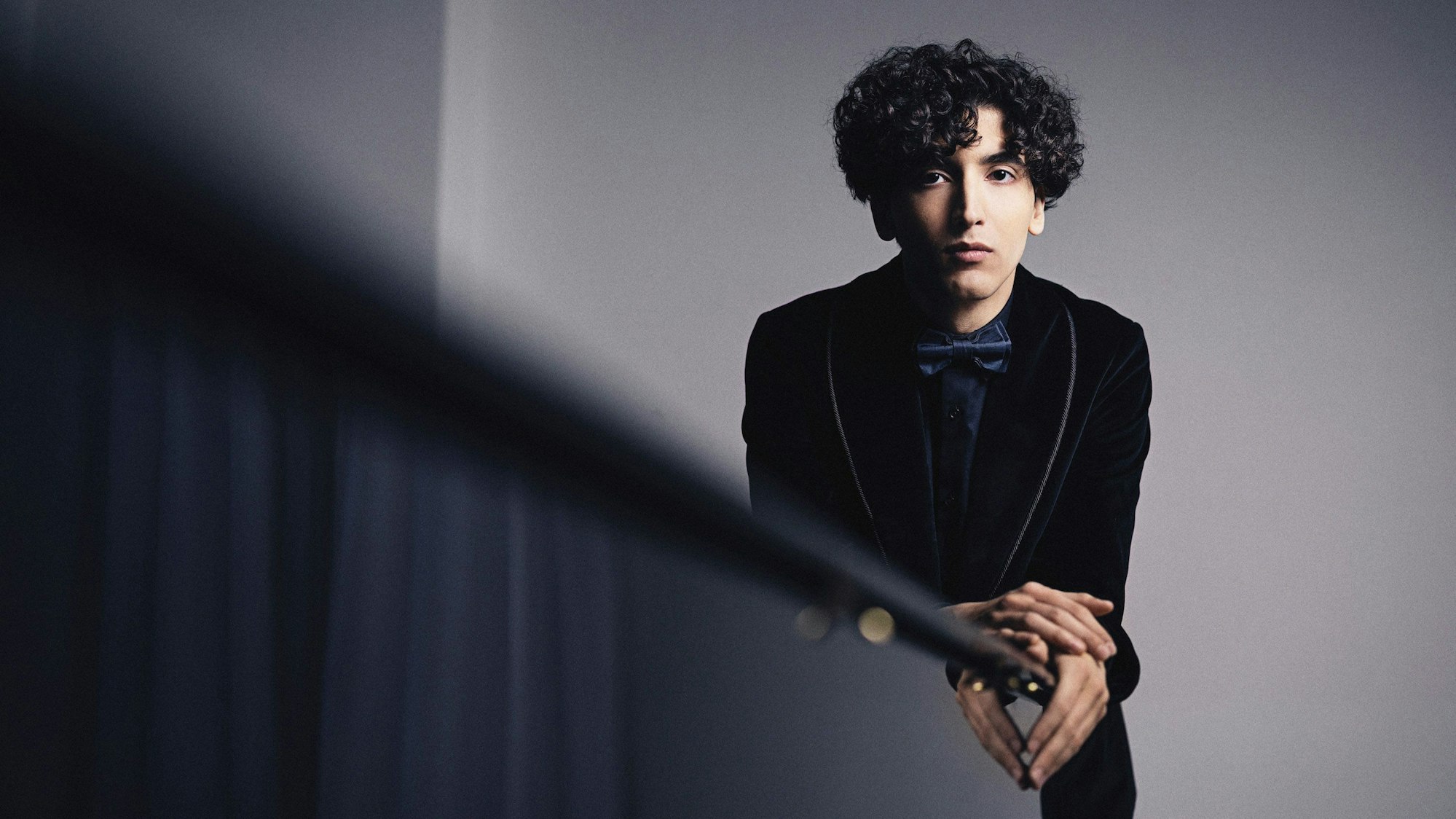 Roman Borisov lehnt an einem Klavier.