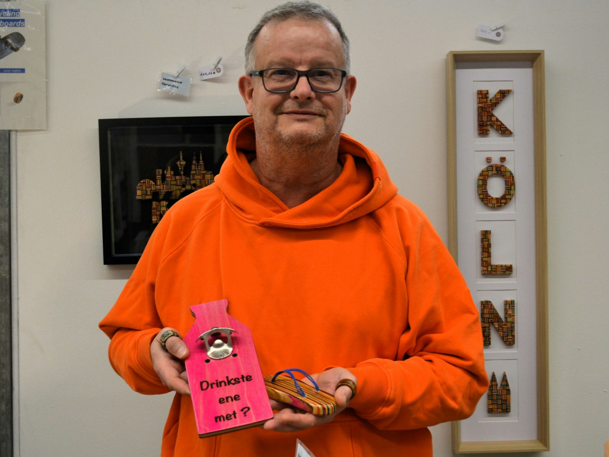 Ein Mann hält eines seiner Kunstwerke in den Händen.