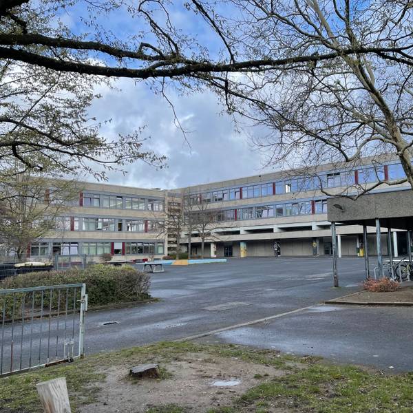Blick über den Pausenhof auf das Schulgebäude.