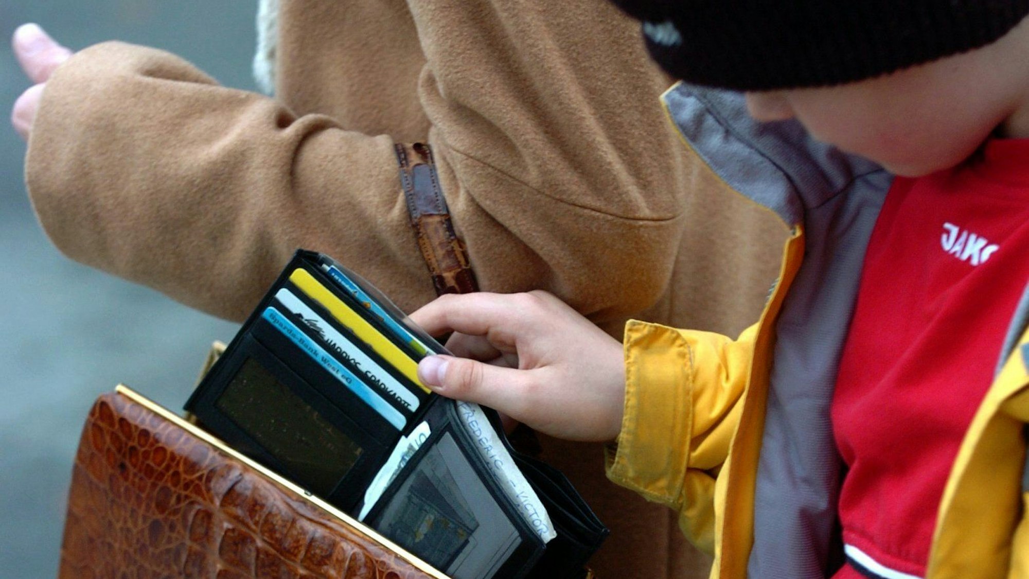Ein Junge stiehlt in Düsseldorf einer Frau eine Geldbörse aus der Handtasche