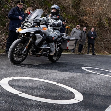 Innenminister Herbert Reul (2.v.r, CDU) und Verkehrsminister Oliver Michael Krischer (r, Bündnis 90/Die Grünen) schauten sich die in Kurven beliebter Motorradstrecken aufgemalten Ellipsen an. Sie sollen verhindern, dass Motorradfahrer die Kurven schneiden.