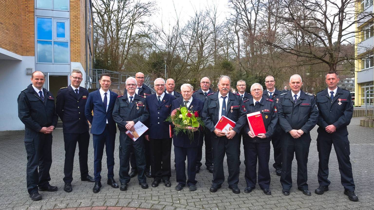 Ein Gruppenfoto von Feuerwehrmännern, die für ihre langjährige Mitgliedschaft geehrt wurden.