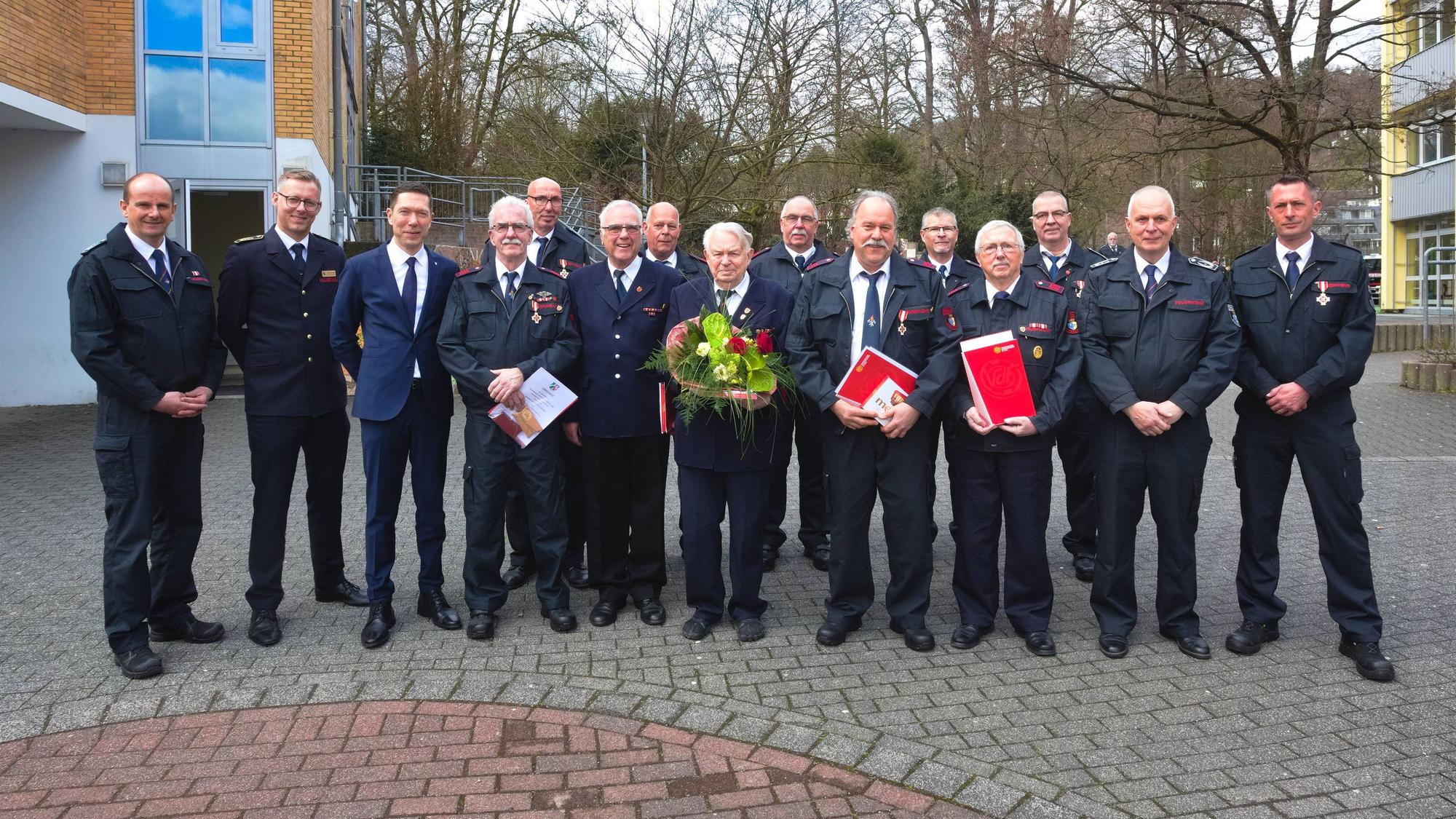 Ein Gruppenfoto von Feuerwehrmännern, die für ihre langjährige Mitgliedschaft geehrt wurden.