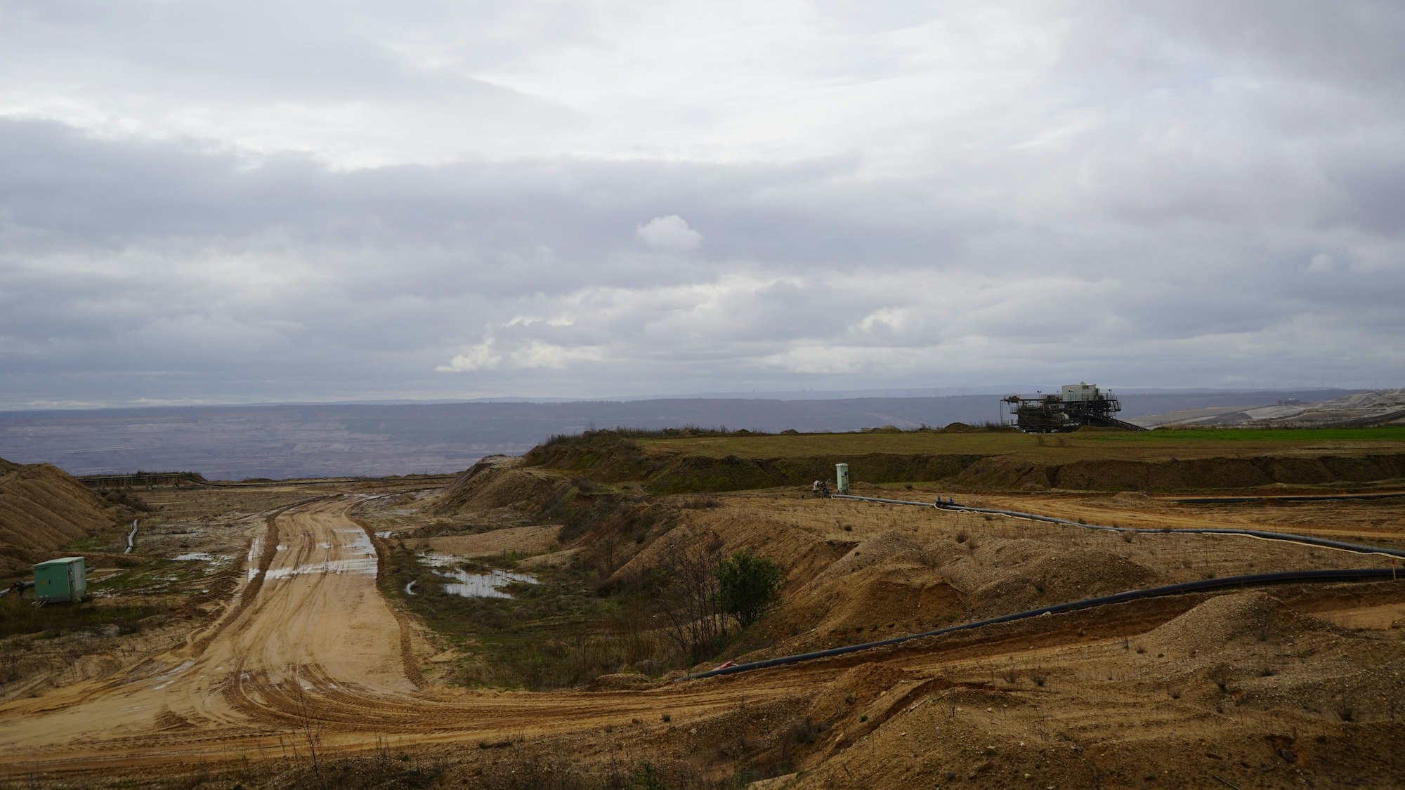 Das Bild zeigt die Tagebaukante, im Hintergrund das große Loch.