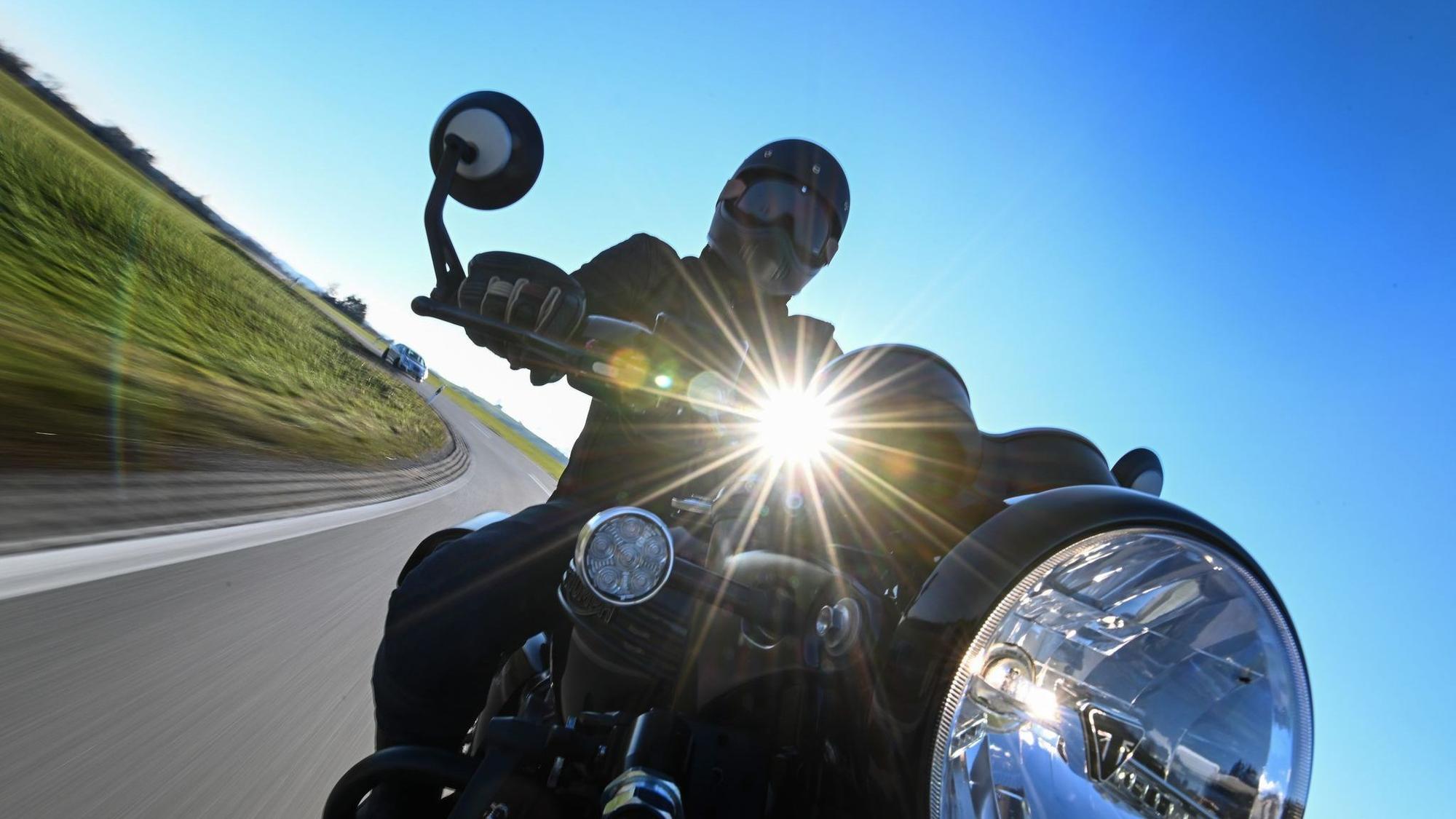 Motorradfahrer fährt eine Landstraße entlang