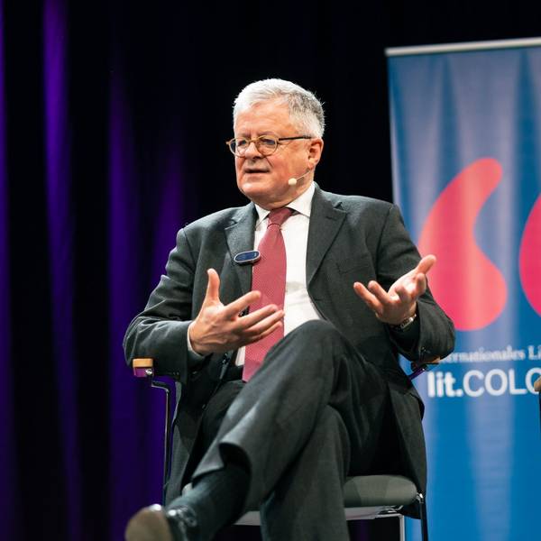 Christopher Clark sitzt auf einer Bühne und redet.