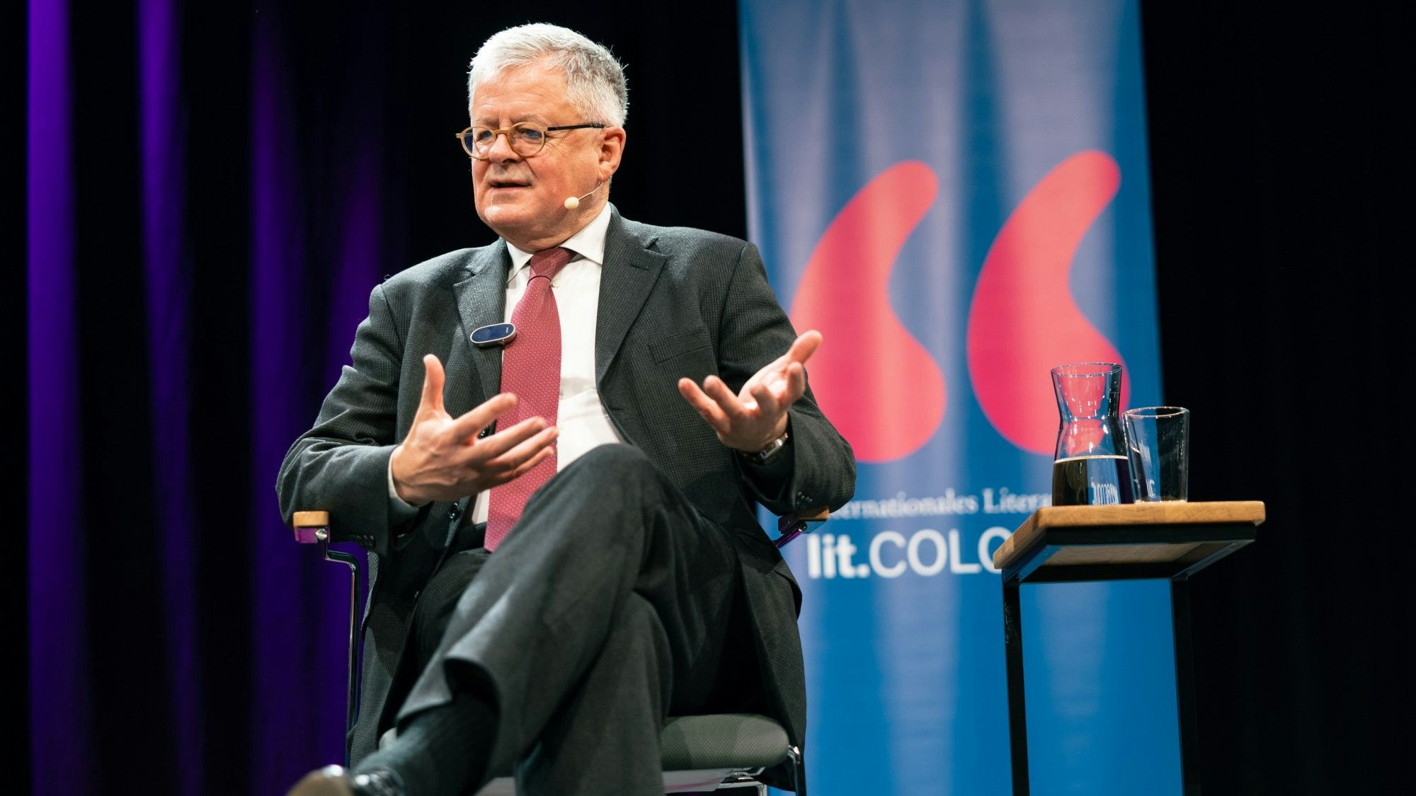 Christopher Clark sitzt auf einer Bühne und redet.