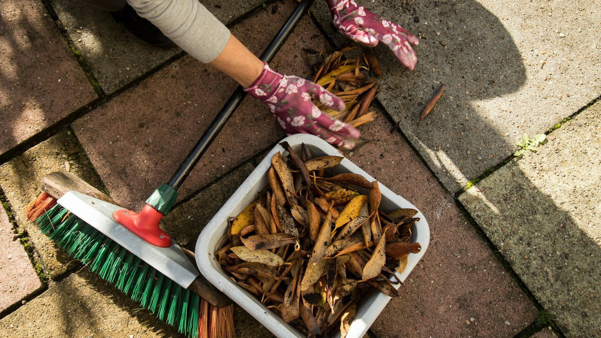 Frau säubert eine Terrasse
