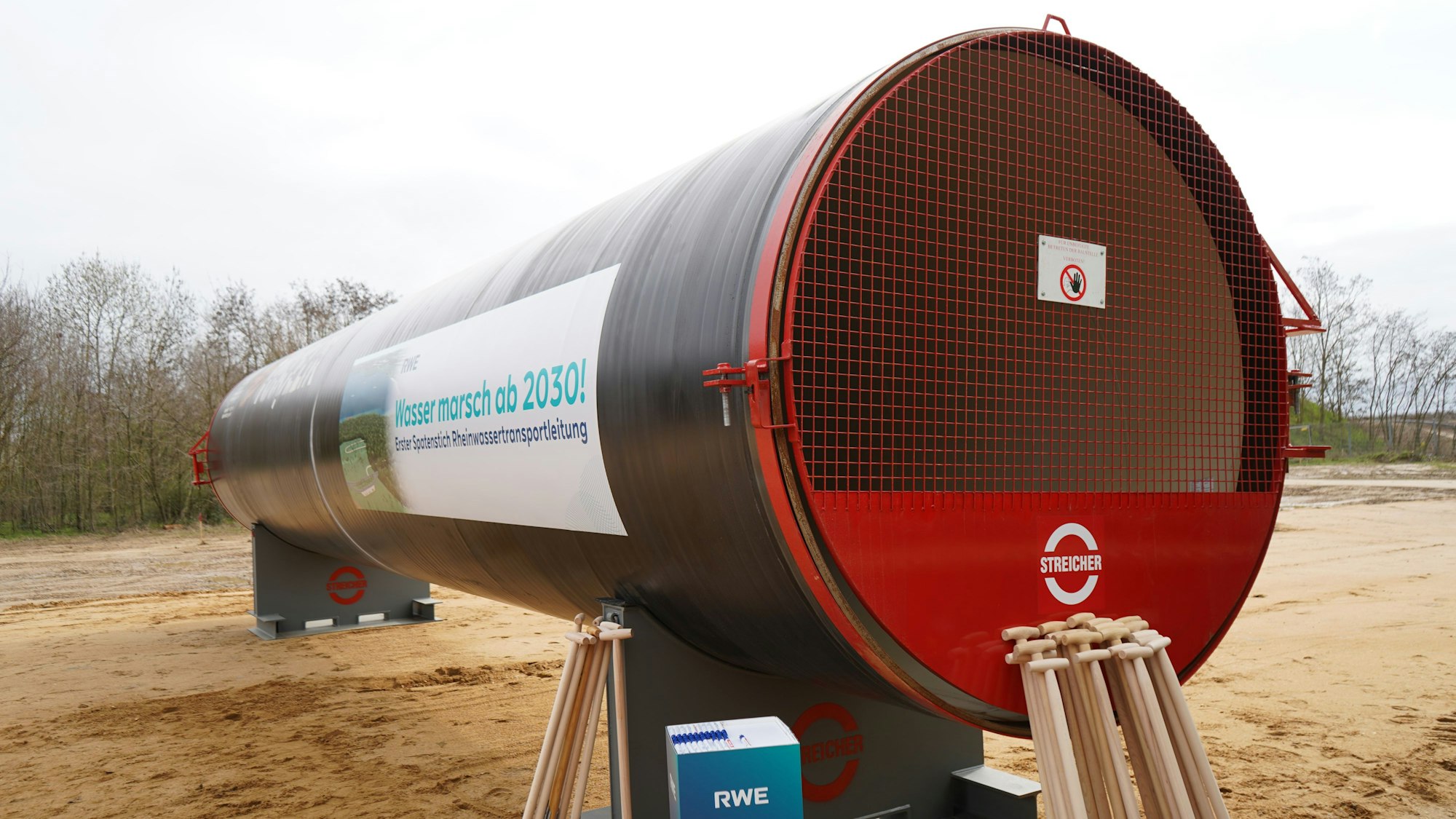 Das Bild zeigt das Rohr. Daran lehnen einige Spaten.