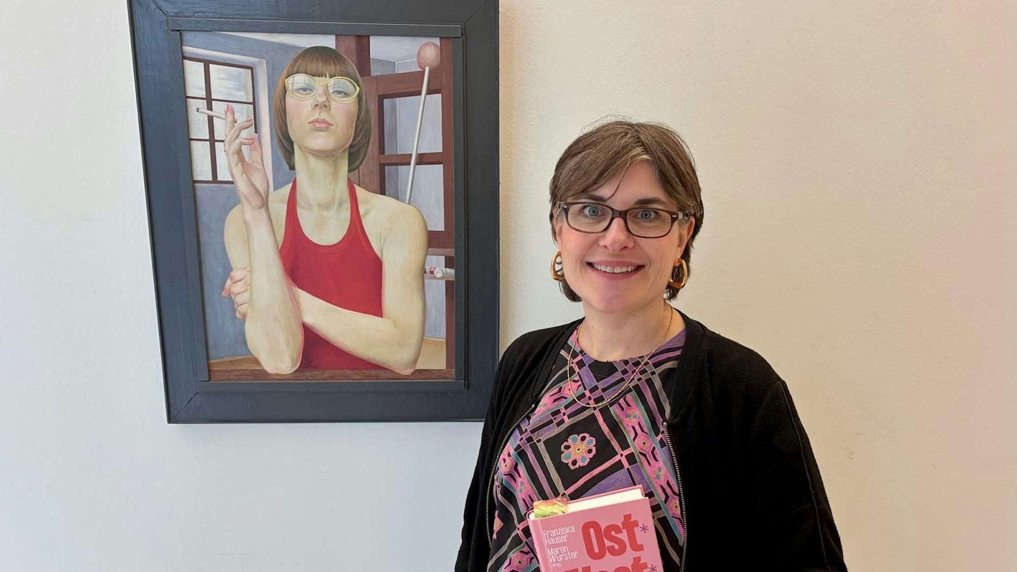 Anna Bründl steht vor einem Gemälde im Kreishaus, das eine Frau zeigt.
