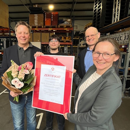 Geschäftsführer Andreas Winkelmann und Auszubildender Marco Dettmann erhalten das Zertifikat von Volker Zilles und Nicole Jordy.