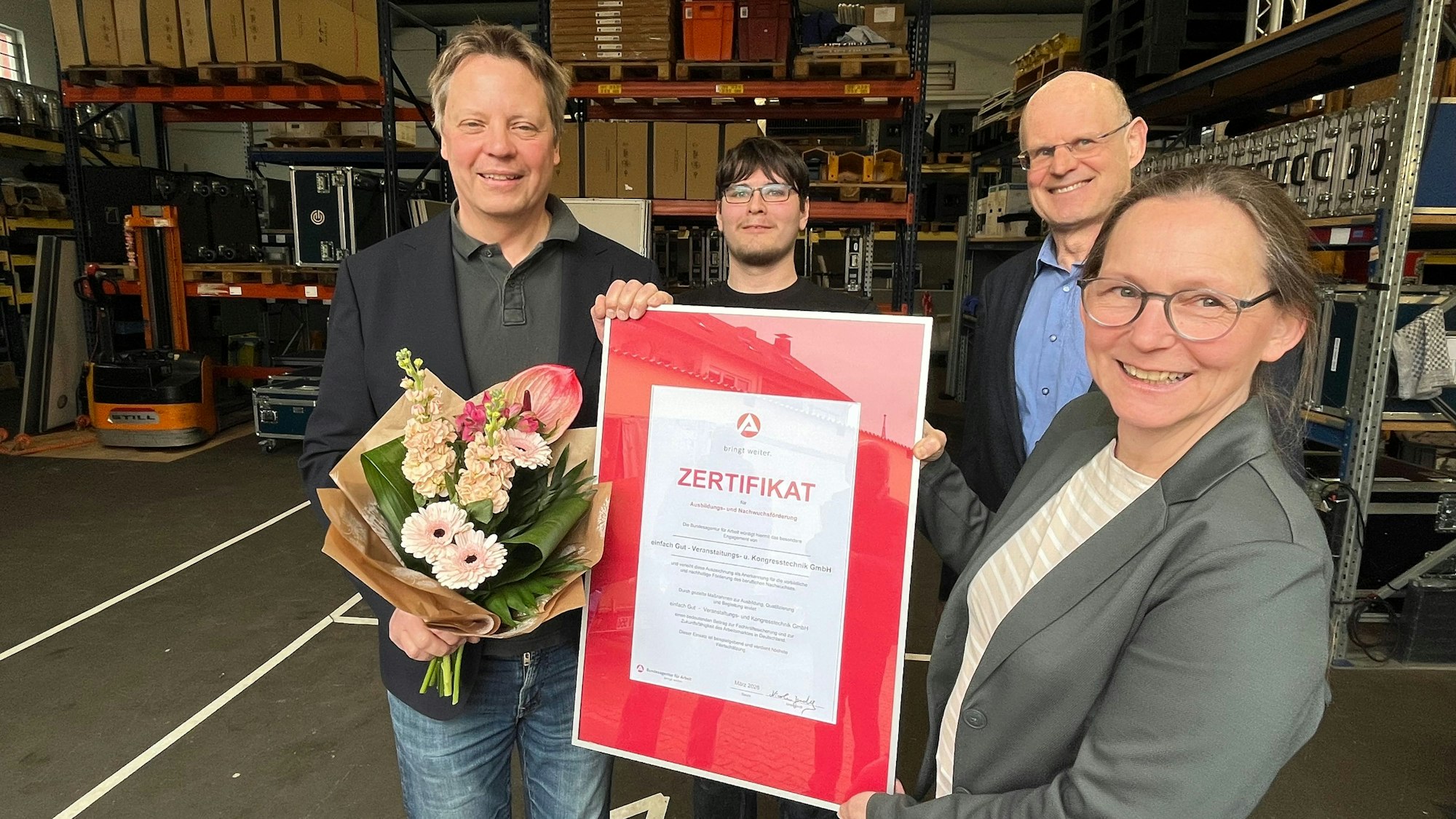Geschäftsführer Andreas Winkelmann und Auszubildender Marco Dettmann erhalten das Zertifikat von Volker Zilles und Nicole Jordy.