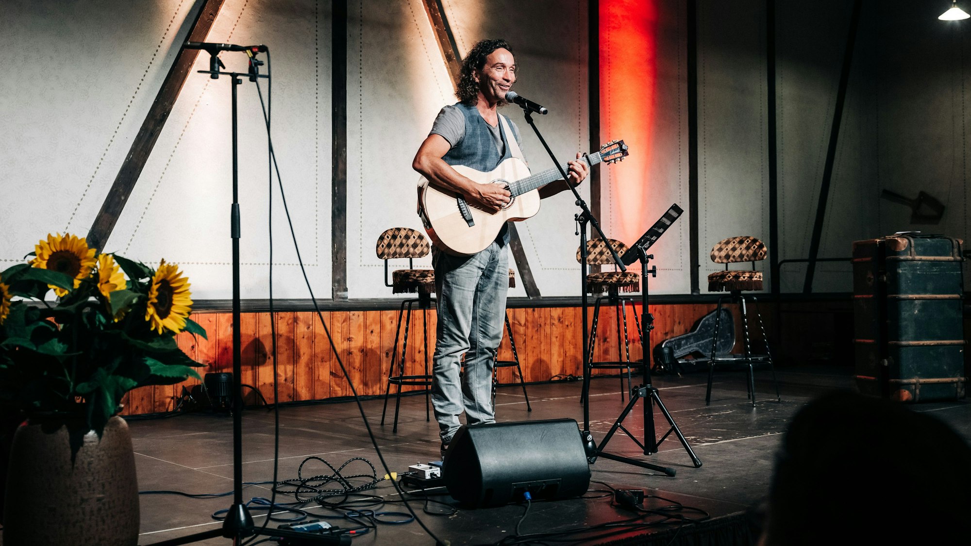 Stephan Brings spielt Gitarre und singt auf einer Bühne.