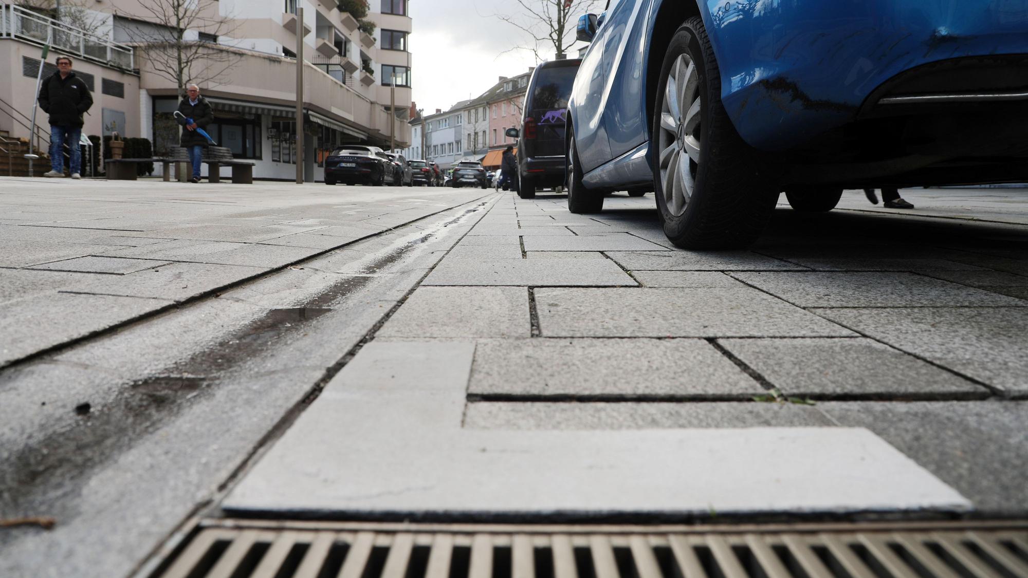 Auf dem Asphalt ist neben einem Autoreifen ein weißer Winkel aufgetragen.